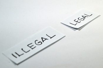 Dos folios doblados por la mital con las palabras ilegal y legal, respectivamente.