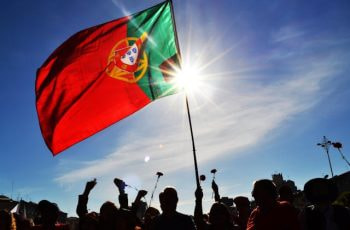 Bandera de Portugal sostenida por un grupo de personas.