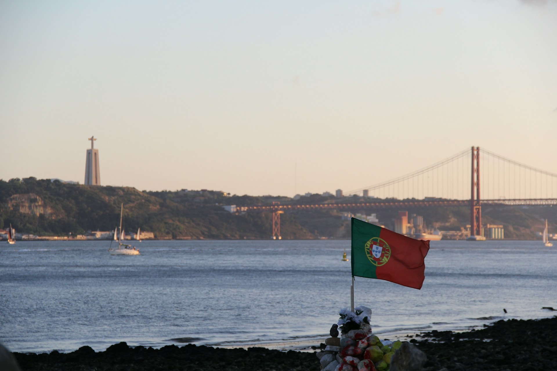 Bandera portuguesa a orillas del río Tajo en su paso por Lisboa bajo el puente 25 de abril.