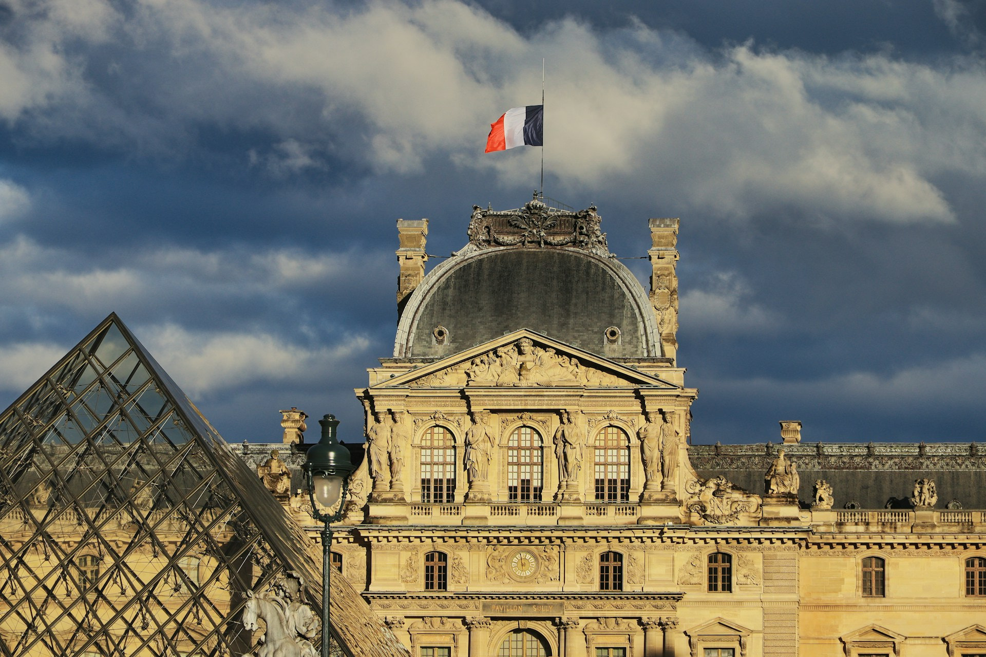 Parte de la fachada y pirámide del Museo del Louvre en París.