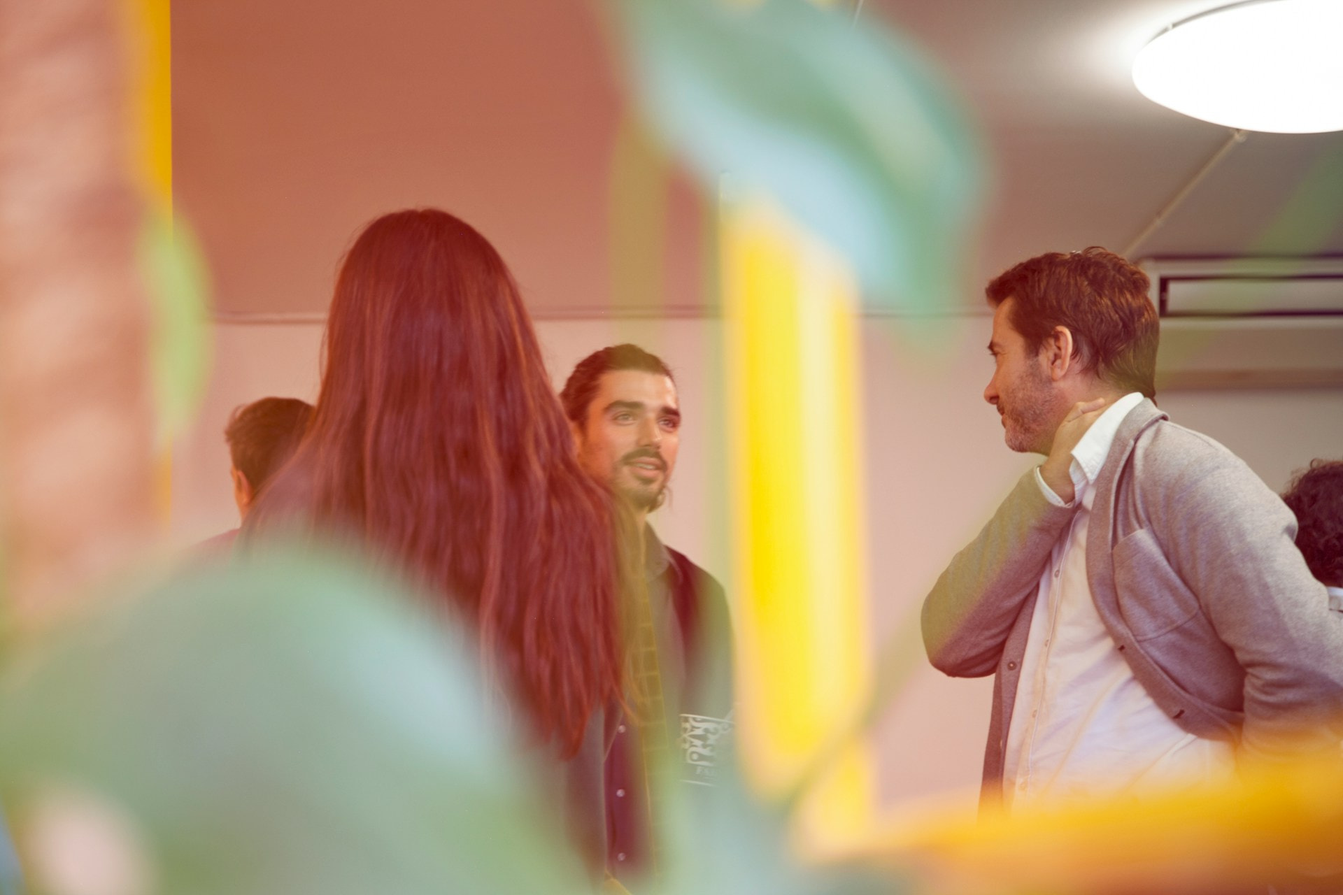 Tres personas hablando en un evento corporativo.