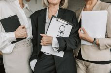 Tres mujeres ejecutivas sosteniendo cada una de ellas un dosier.